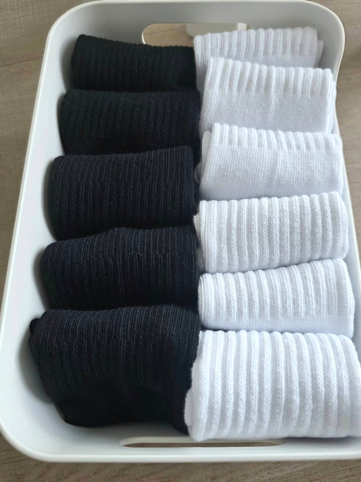 Drawer insert with socks rolled and separated by colour
